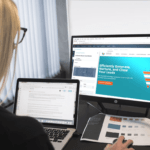 Image of a web designer working in front of a desktop and laptop
