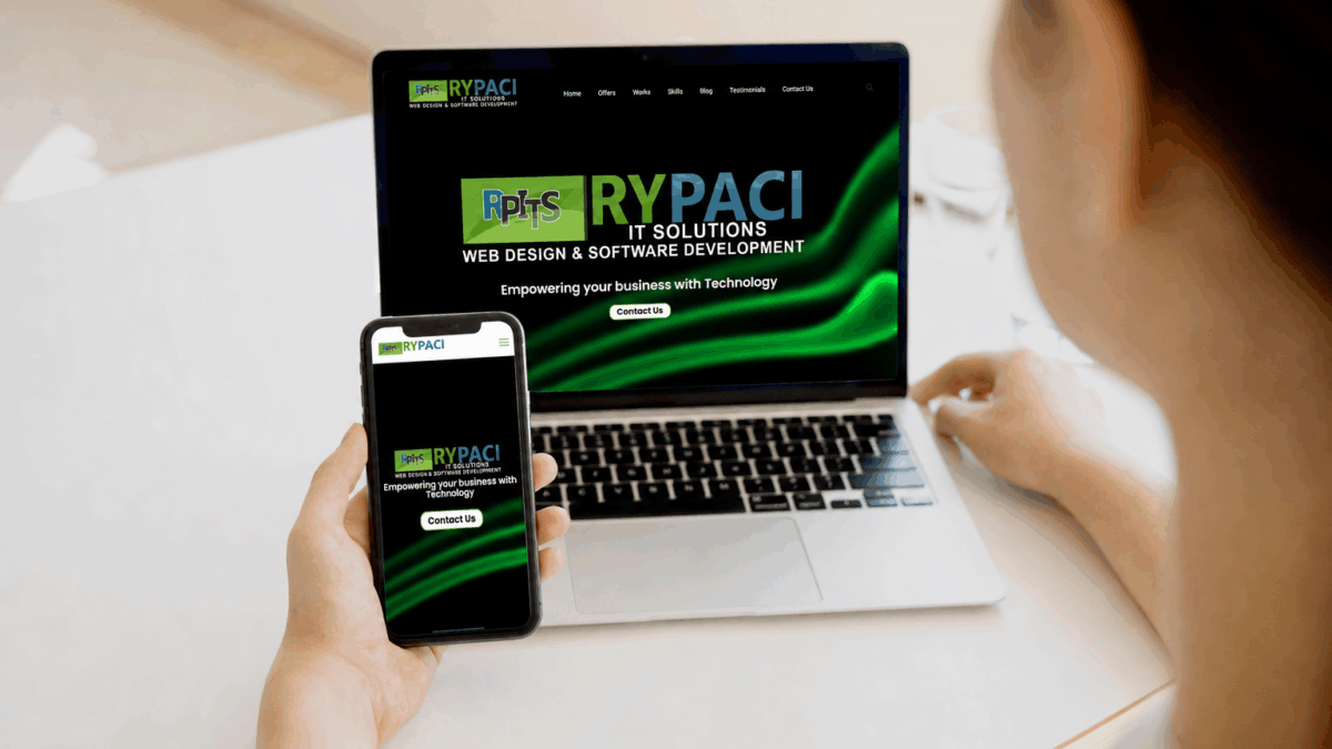 Woman holding a smartphone beside a laptop for mobile-friendly website design