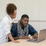 Business professionals comparing website design and custom software on a laptop